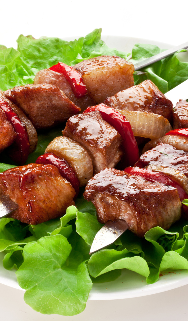 Аппетитный шашлык с листьями салата на шампурах 