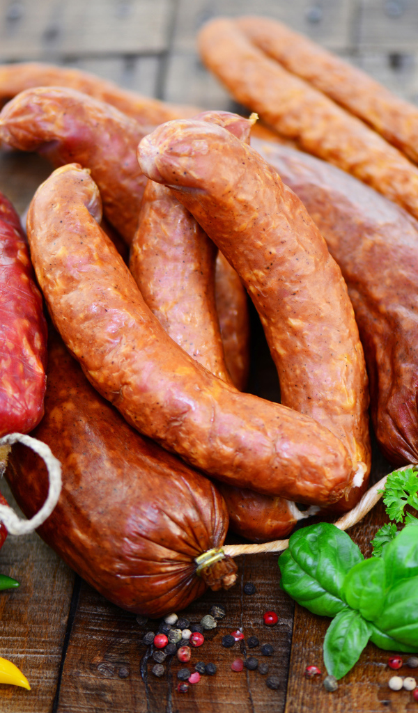 Свежие колбасы с перцем на столе