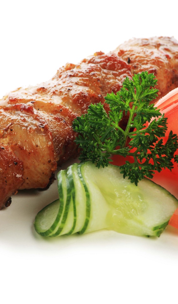 Шашлык с огурцами, помидорами и зеленью на белом фоне