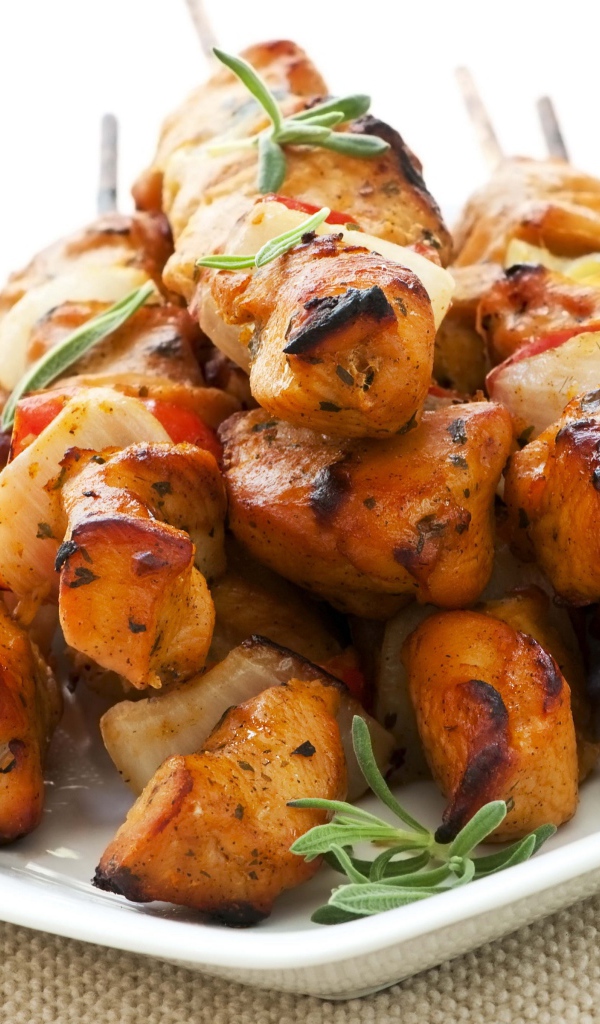 Шашлыки на белой тарелке с зеленью розмарина