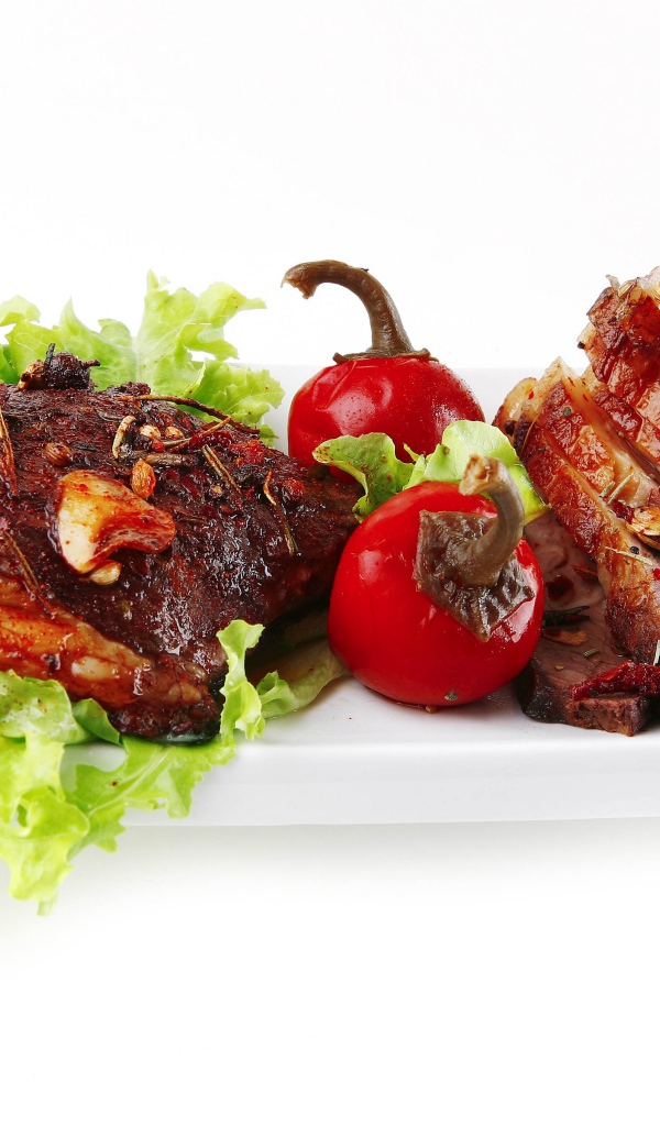 Мясо с листьями салата и красным перцем на белом фоне