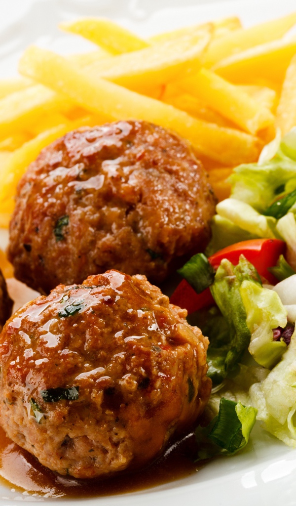 Тефтели с картофелем фри и салатом на белой тарелке 