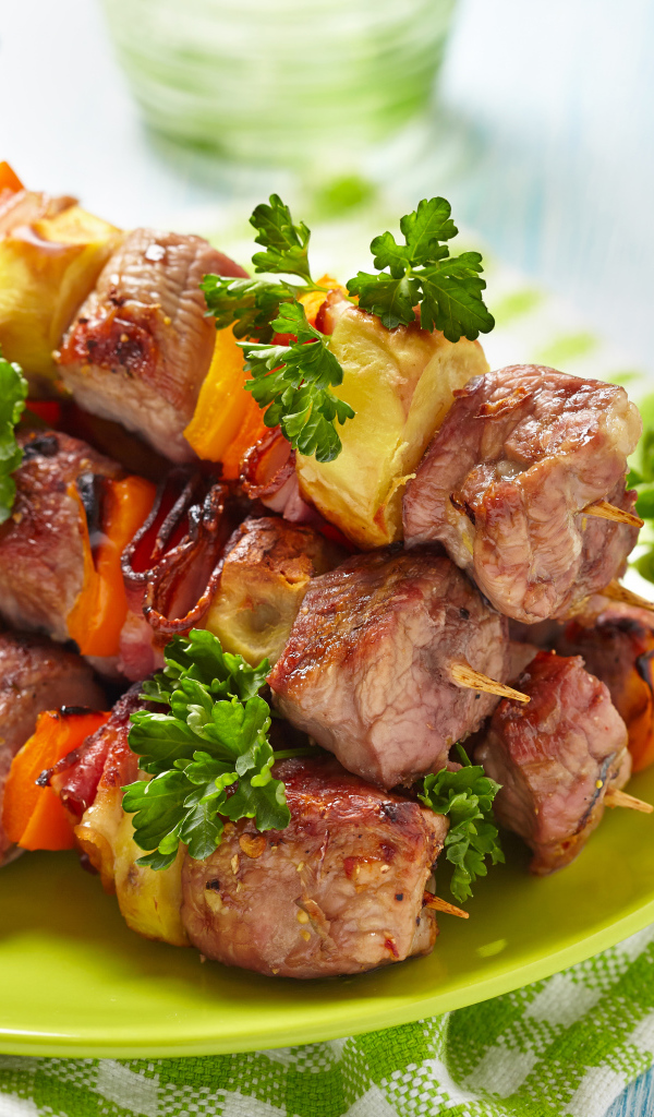 Шашлык с овощами на тарелке на столе