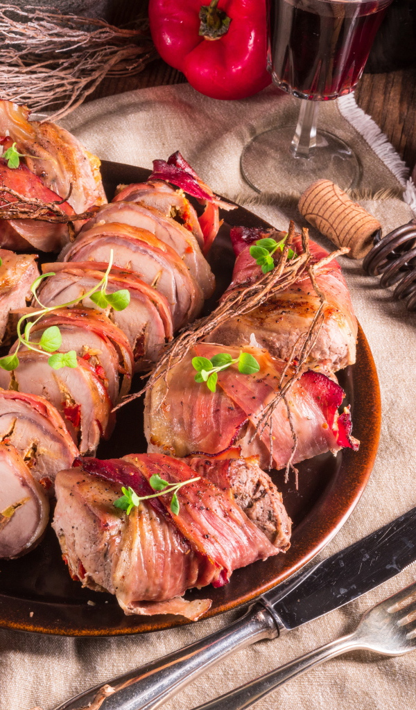 Нарезанные мясные рулеты на столе с хлебом