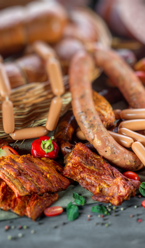 Копченые ребрышки с колбасой на столе 