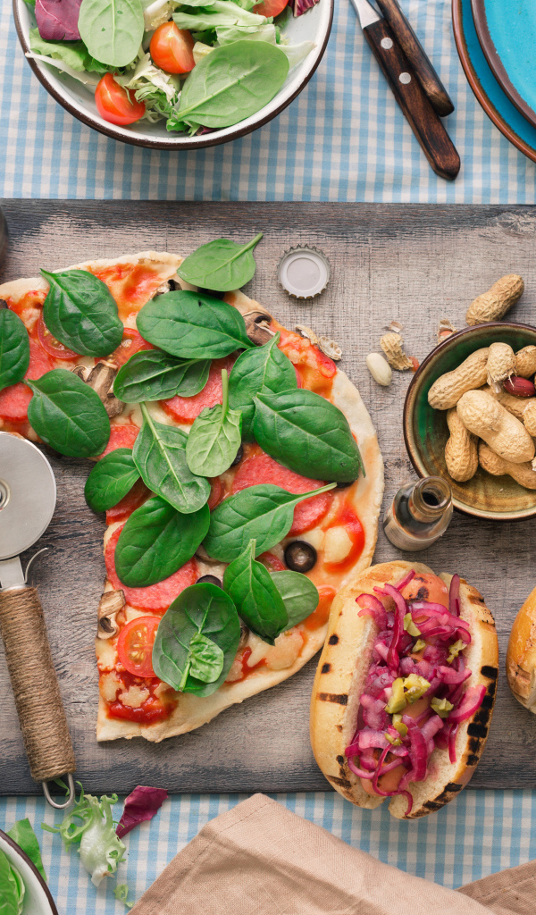 Пицца с хотдогами на столе с соусом