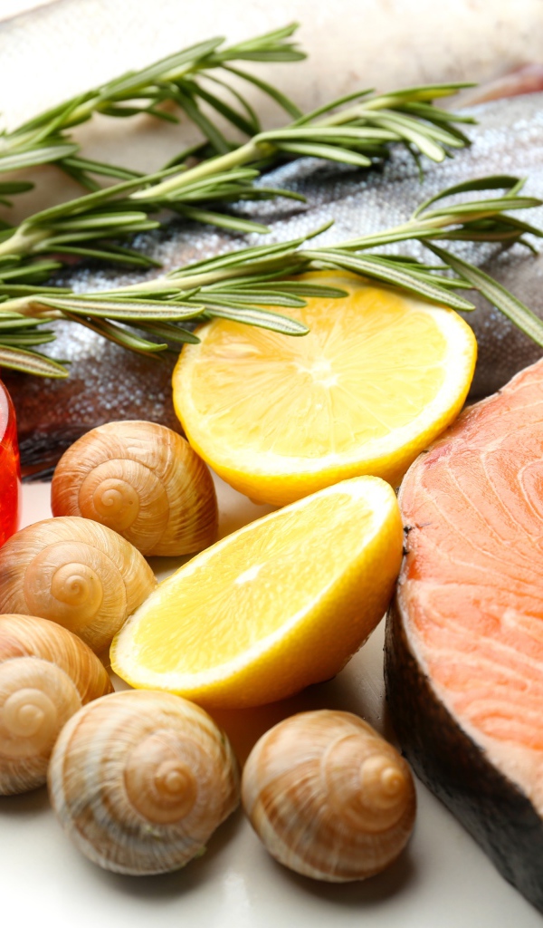 Красная рыба с улитками и красной икрой на столе с лимоном и базиликом