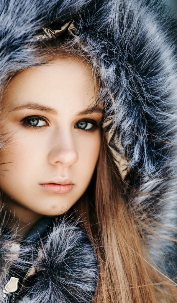Молодая девушка в меховом капюшоне 
