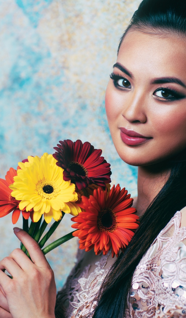Красивая девушка азиатка с букетом гербер в руках