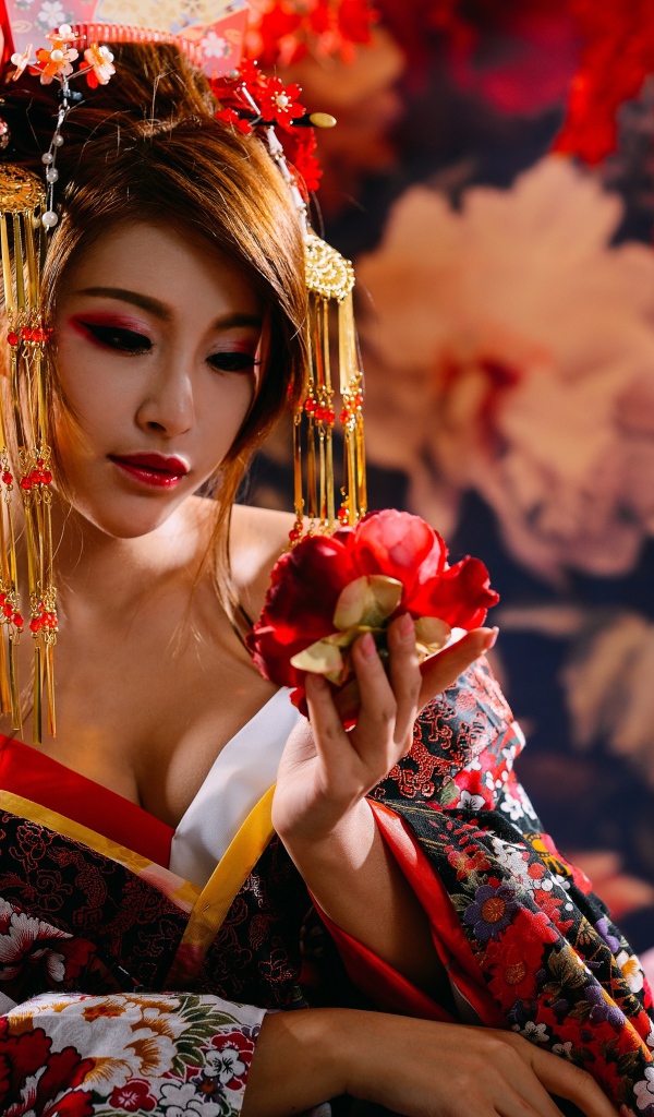 Красивая девушка азиатка в кимоно с цветком в руке