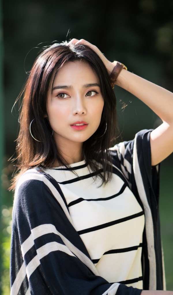 Красивая девушка азиатка с часами на руке 