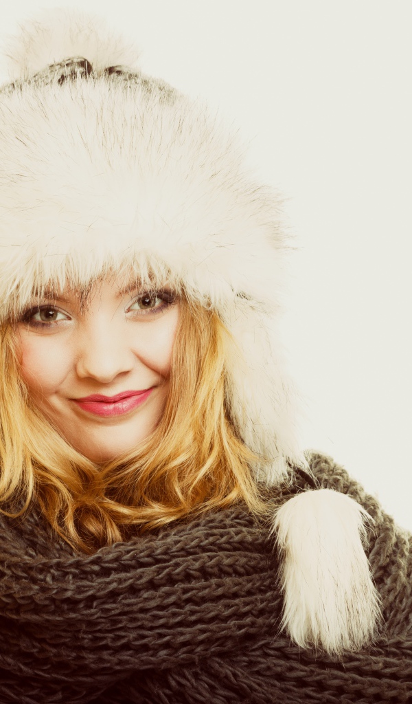Красивая блондинка в теплой шапке с шарфом на шее