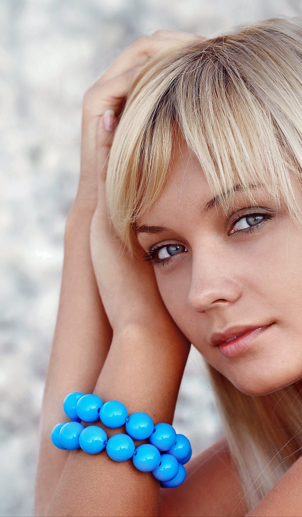 Красивая блондинка с большим голубым браслетом на руке