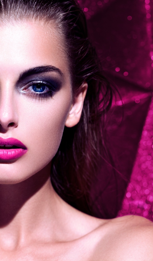 Красивая голубоглазая брюнетка с макияжем на сиреневом фоне