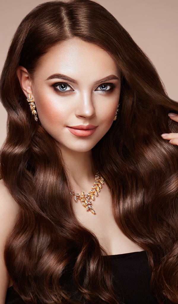 Красивая голубоглазая длинноволосая девушка шатенка с золотым украшением на шее 