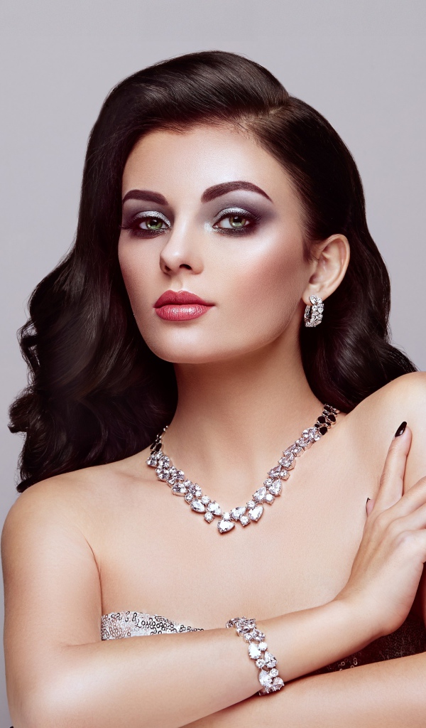 Красивая яркая брюнетка на сером фоне