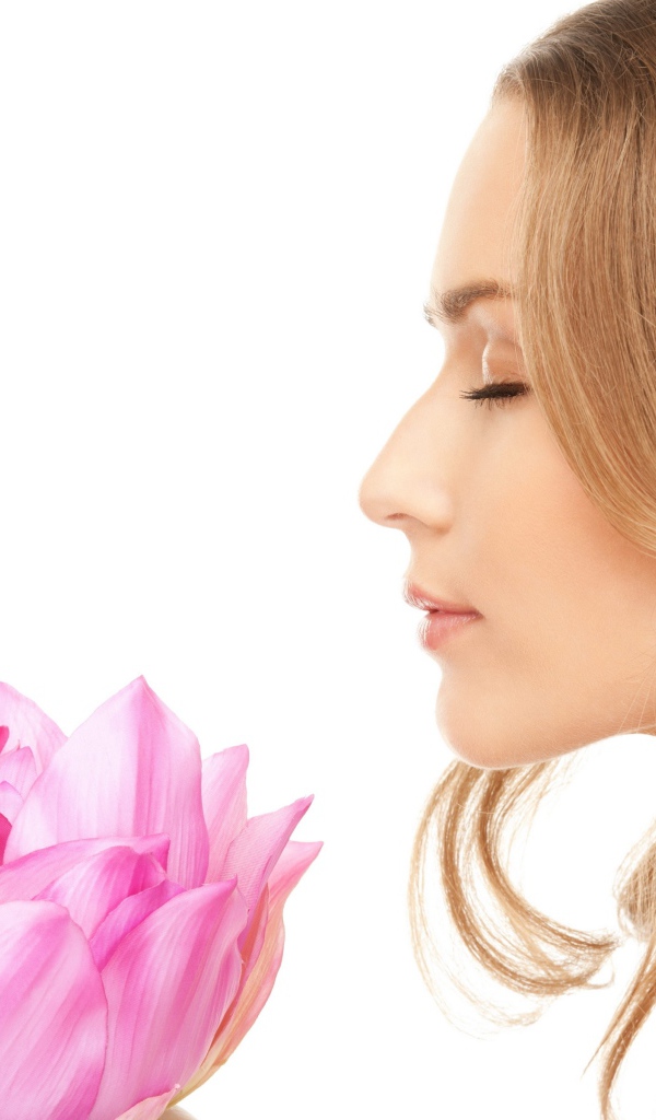 Красивая девушка шатенка наслаждается ароматом лотоса 