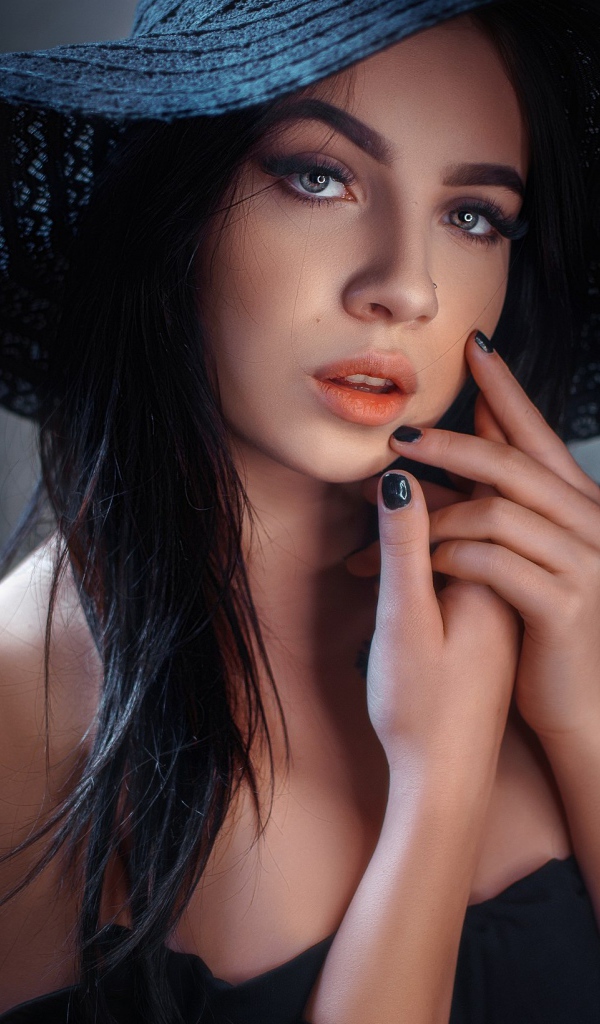 Красивая брюнетка в большой черной шляпе 