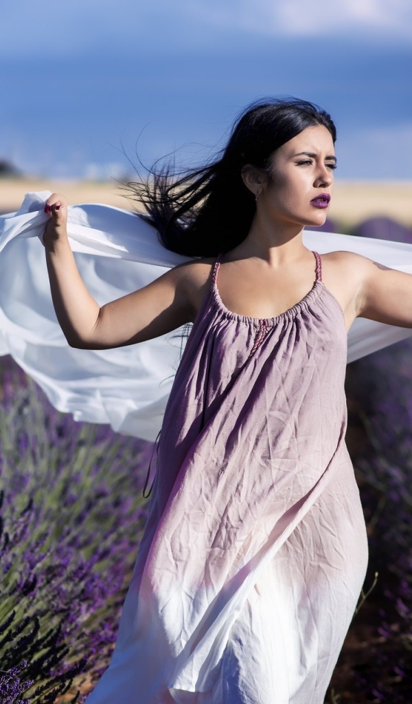 Красивая брюнетка в сарафане гуляет по лавандовому полю