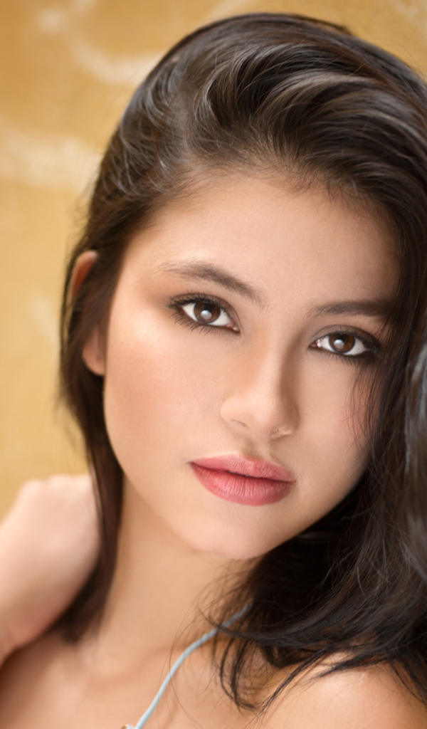 Красивая брюнетка на фоне стены 