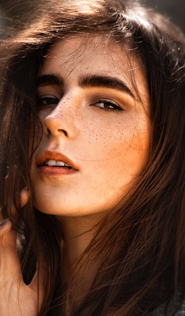 Красивая брюнетка с веснушками на лице