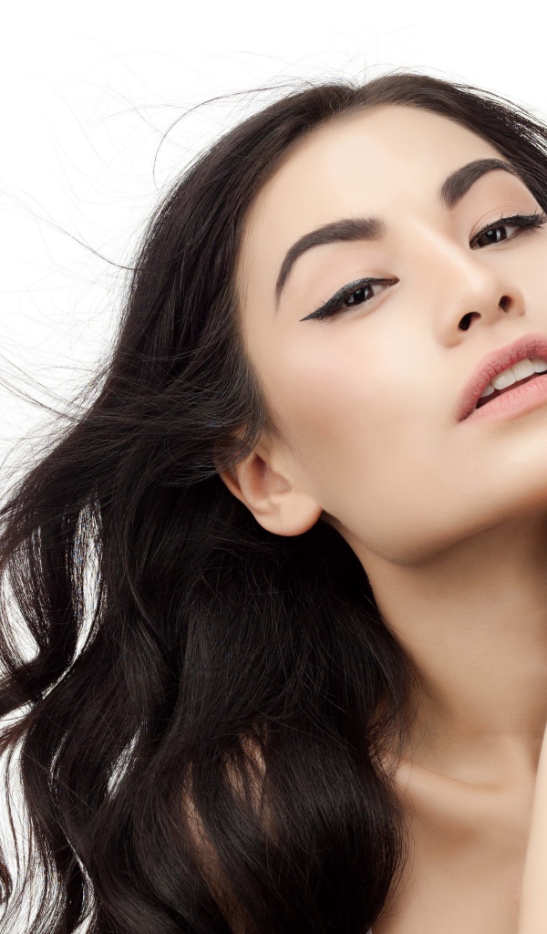 Красивая брюнетка с накрашенными глазами на белом фоне