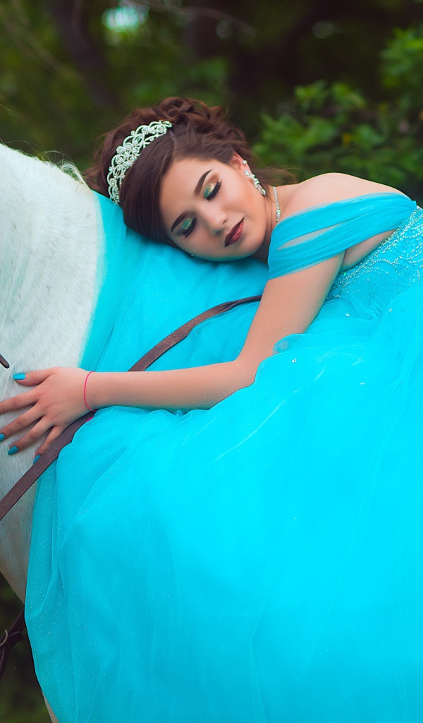 Красивая девушка в пышном голубом платье на лошади