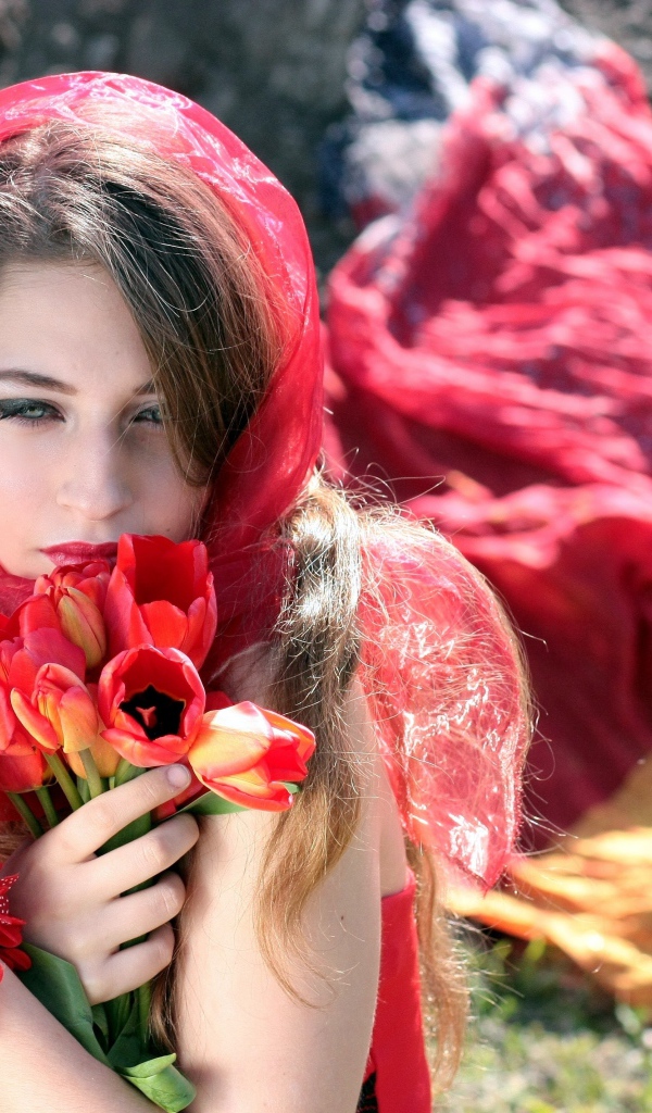 Красивая девушка в красной шали с букетом тюльпанов