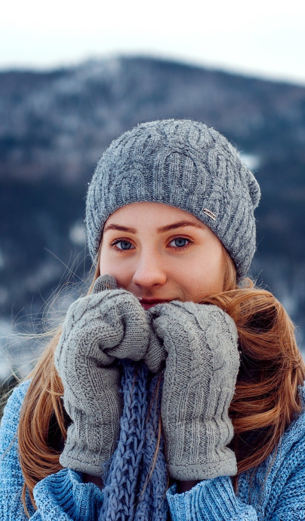 Красивая девушка в теплой шапке и варежках