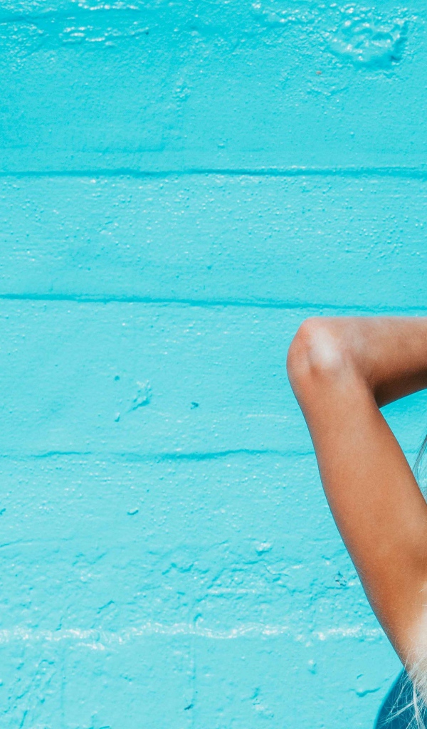 Красивая девушка в солнечных очках загорает на солнце летом