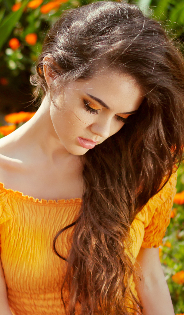 Красивая девушка у цветов календулы