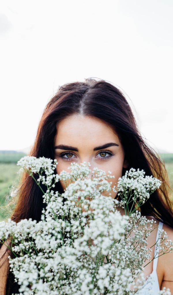 Красивая девушка с букетом полевых цветов