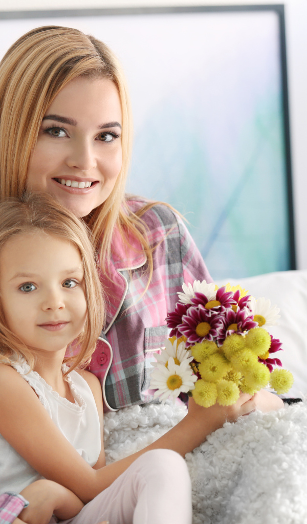 Красивая девушка с маленькой девочкой и букетом цветов