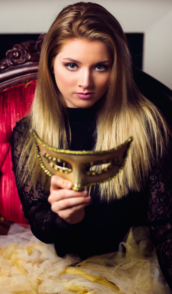 Красивая девушка с маской в руках