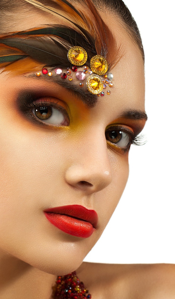 Красивая девушка с ярким макияжем и стразами на лице