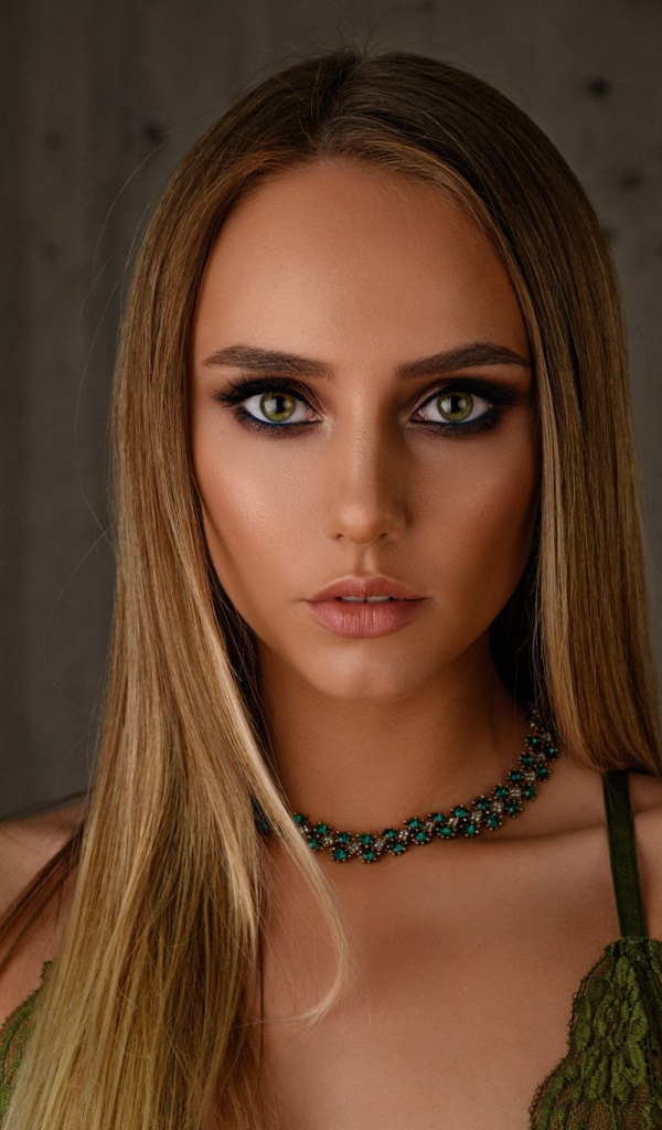 Красивая длинноволосая блондинка с украшением на шее 