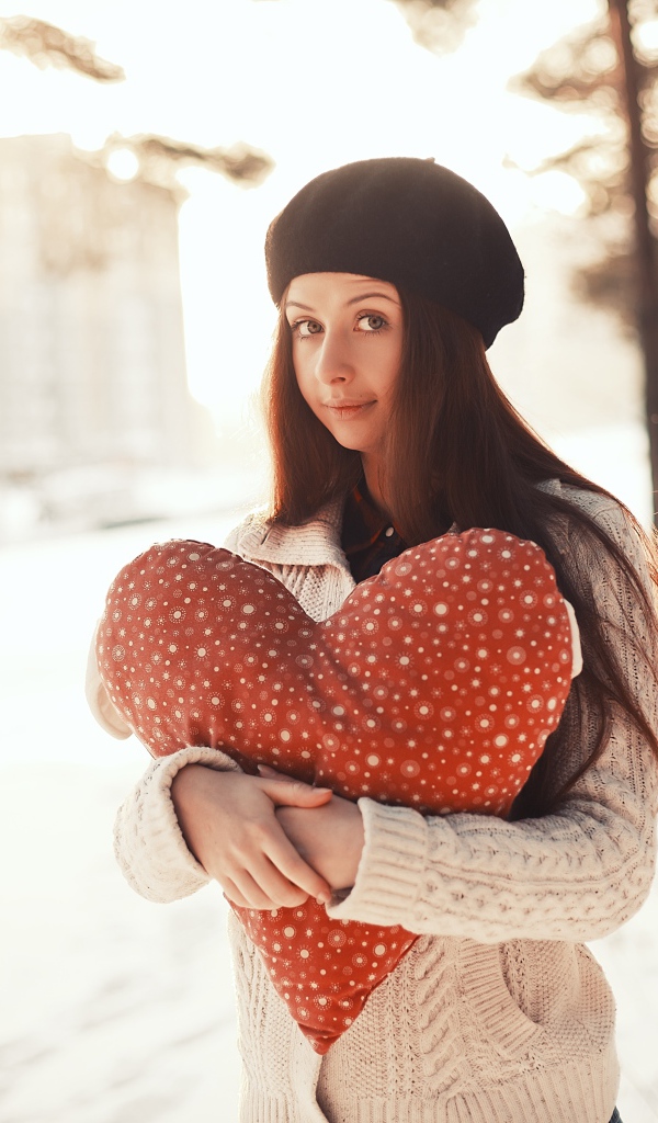 Красивая длинноволосая шатенка с игрушечным сердцем 