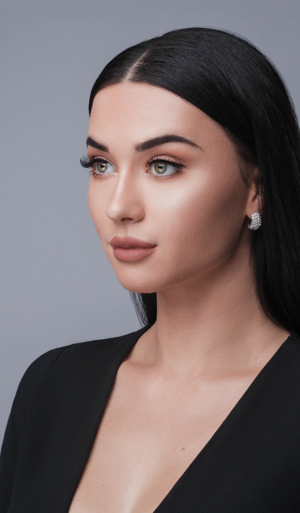 Красивая длинноволосая брюнетка в черном фото на сером фоне