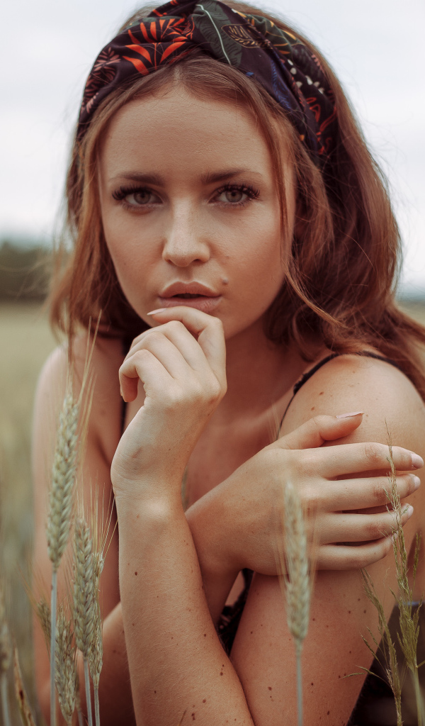 Красивая рыжеволосая девушка на поле с пшеницей