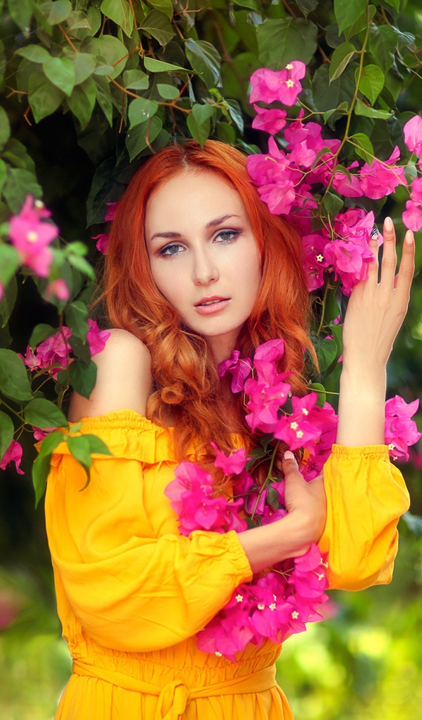 Красивая рыжеволосая девушка с розовыми цветами