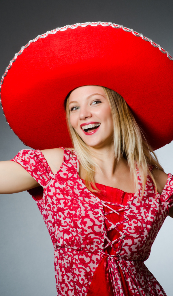 Красивая улыбающаяся блондинка в большой красной шляпе