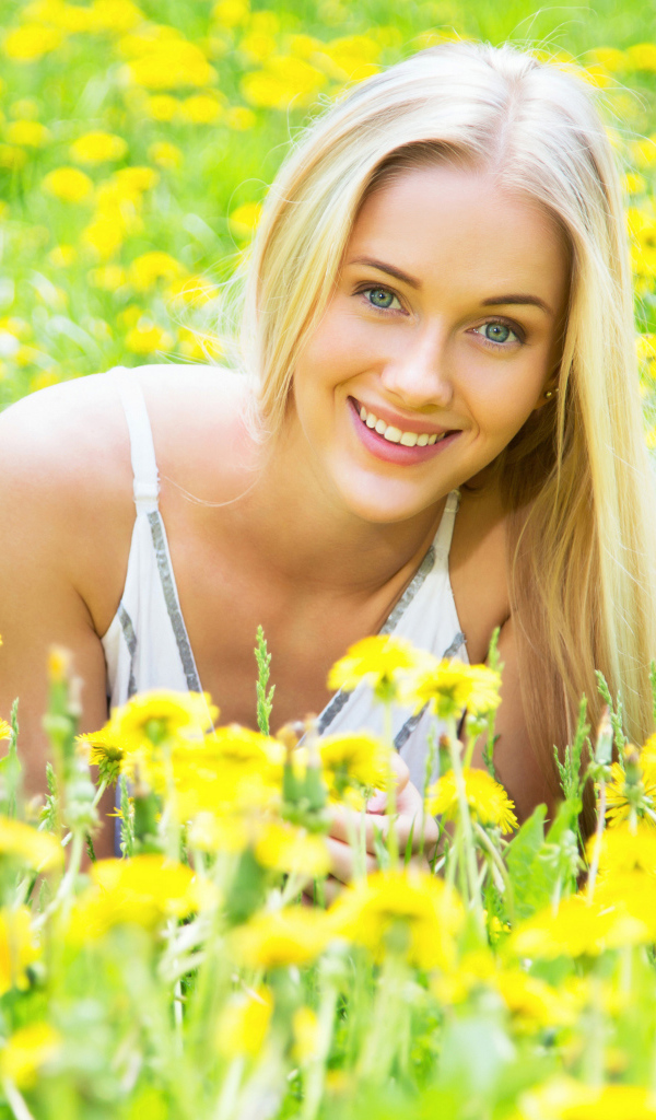 Красивая улыбающаяся блондинка в желтых одуванчиках