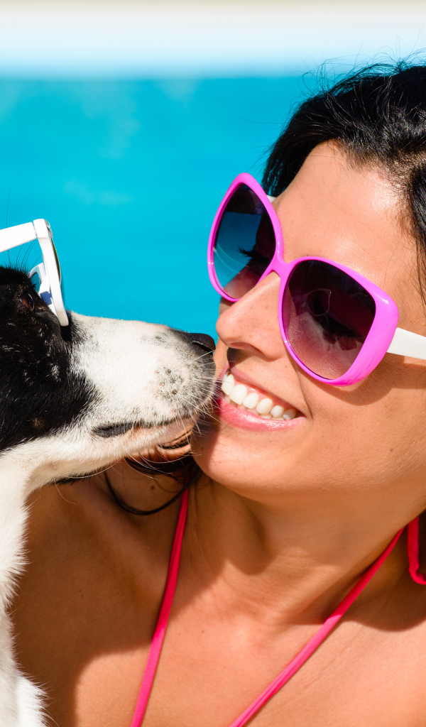 Красивая улыбающаяся девушка в солнечных очках с собакой 