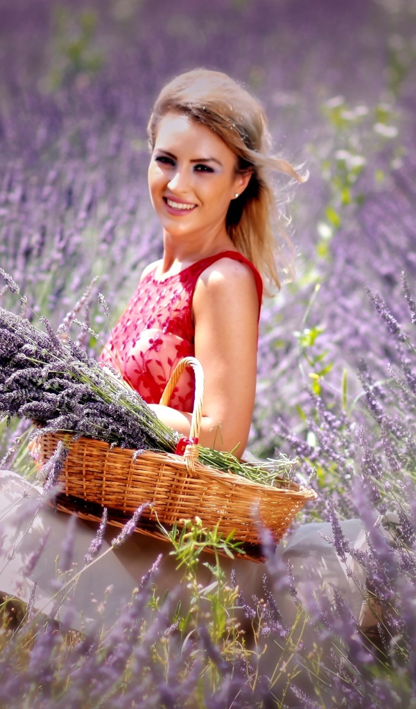 Красивая улыбающаяся девушка с корзиной на лавандовом поле