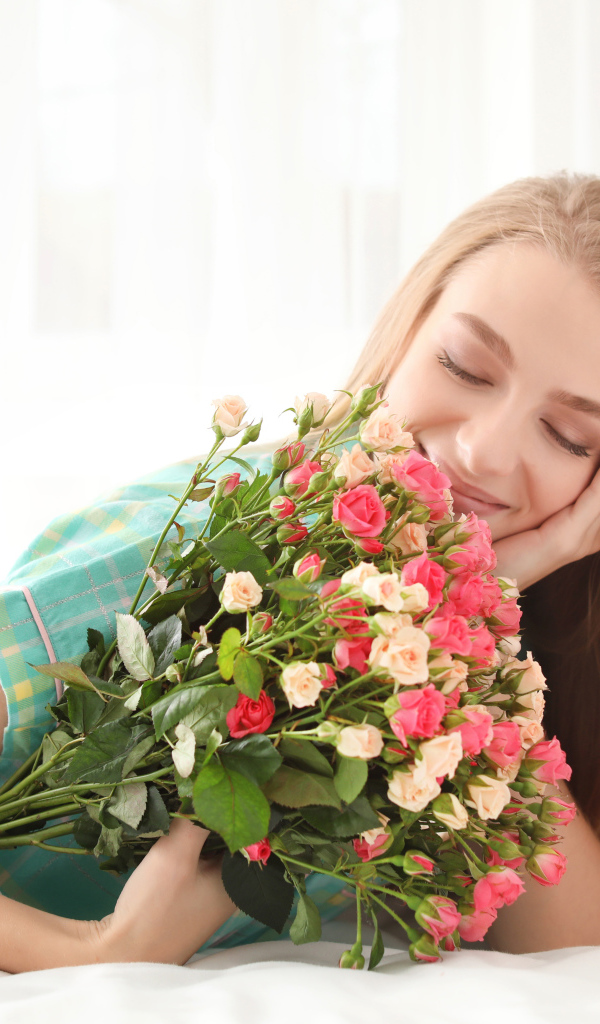 Красивая улыбающаяся девушка с букетом роз
