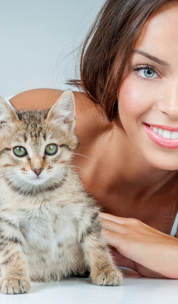 Красивая улыбающаяся девушка с серым котенком