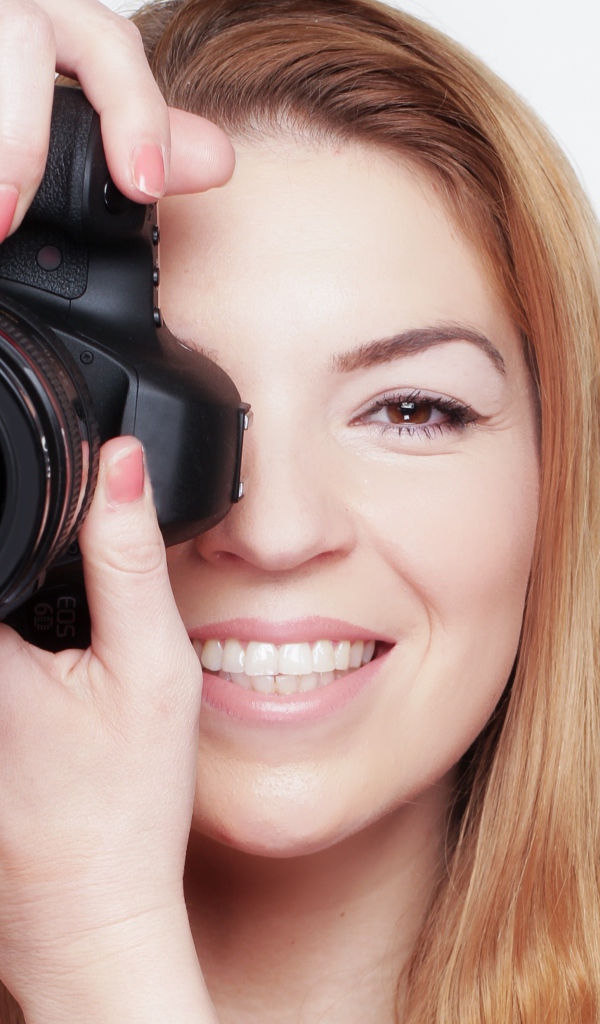 Красивая улыбающаяся девушка с фотоаппаратом