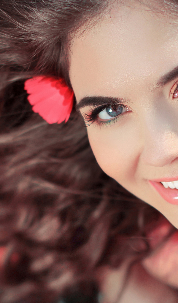 Красивая улыбающаяся девушка с цветами в волосах 