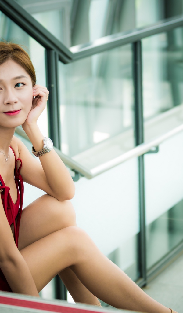 Красивая молодая девушка азиатка сидит на ступенях