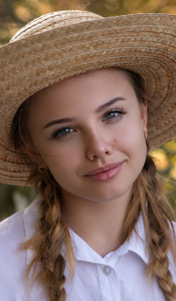 Красивая молодая девушка в соломенной шляпе